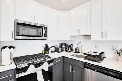 a white kitchen with a stove and a microwave at Spacious Center City 3BR 4BA with Arcade - Sleeps 8 in Philadelphia