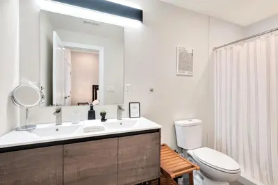 a bathroom with a sink and a toilet and a mirror at Spacious Center City 3BR 4BA with Arcade - Sleeps 8 in Philadelphia