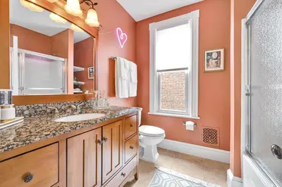 a bathroom with a sink and a toilet and a mirror at Downtown Lancaster Luxury 4BR - Garage & Parking in Lancaster