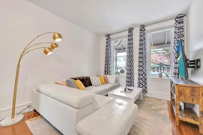 a living room with a white couch and two windows at Downtown Lancaster Luxury 4BR - Garage & Parking in Lancaster