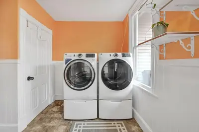a washer and dryer in a laundry room with an orange wall at Downtown Lancaster Luxury 4BR - Garage & Parking in Lancaster
