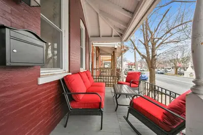 a porch with chairs and a television on a building at Downtown Lancaster Luxury 4BR - Garage & Parking in Lancaster