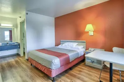 a hotel room with a bed and a sink at Cumberland Inn By OYO New Cumberland-Hershey South in New Cumberland