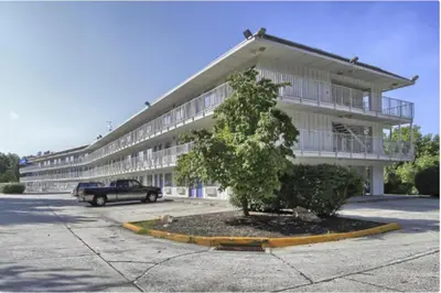 a large building with a tree in front of it at Cumberland Inn By OYO New Cumberland-Hershey South in New Cumberland