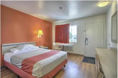 a hotel room with a bed and a desk and a window at Cumberland Inn By OYO New Cumberland-Hershey South in New Cumberland