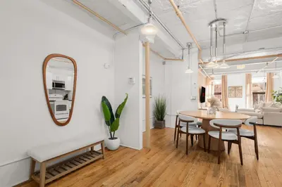 a living room with a table and chairs and a mirror at Beautifully designed 3 BDR in Dumbo NYC in Brooklyn