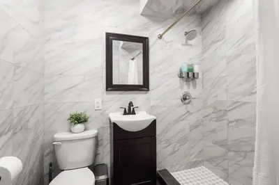 a bathroom with a toilet and a sink and a mirror at Beautifully designed 3 BDR in Dumbo NYC in Brooklyn