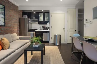 a living room and kitchen with a couch and a table at Explore NYC! Cozy 2BR in Prime Location in New York