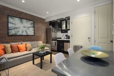 a living room with a couch and a table at Explore NYC! Cozy 2BR in Prime Location in New York