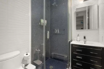 a bathroom with a shower with a toilet and a sink at Explore NYC! Cozy 2BR in Prime Location in New York