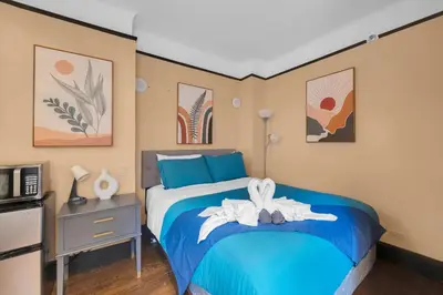 a bedroom with a blue bed and a microwave at NYC Premier Walking Distance to Times Square in New York