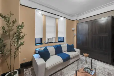 a living room with a white couch and blue pillows at NYC Premier Walking Distance to Times Square in New York