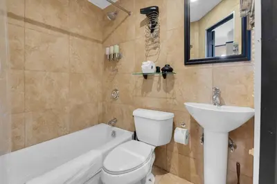 a bathroom with a toilet and a sink and a bath tub at NYC Premier Walking Distance to Times Square in New York