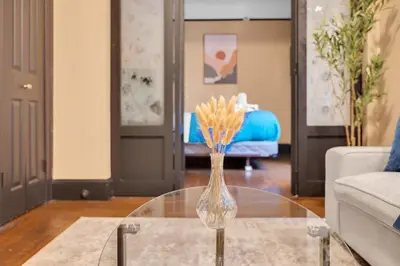 a vase of flowers on a glass table in a living room at NYC Premier Walking Distance to Times Square in New York