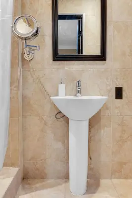 a bathroom with a white sink and a mirror at NYC Apartment in The Best Location! Walking Distance to Everything! in New York
