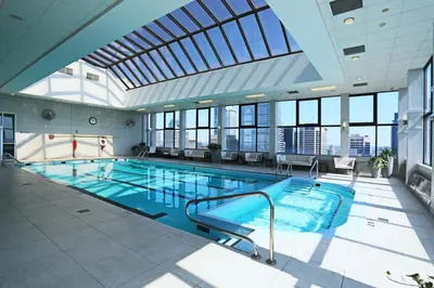 a large swimming pool in a building with windows at 1500 Locust Apartments Luxury Living in the Heart of Philadelphia in Philadelphia
