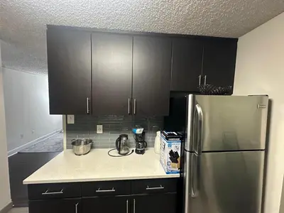 a kitchen with black cabinets and a stainless steel refrigerator at 1500 Locust Apartments Luxury Living in the Heart of Philadelphia in Philadelphia