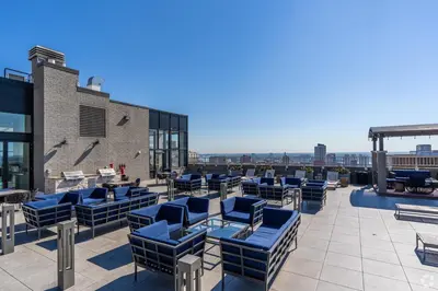 a patio with blue chairs and tables on a building at 1500 Locust Apartments Luxury Living in the Heart of Philadelphia in Philadelphia