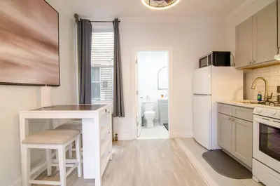 a kitchen with white cabinets and a white refrigerator at Fireflies In NYC, Cozy, Private & New in Union City