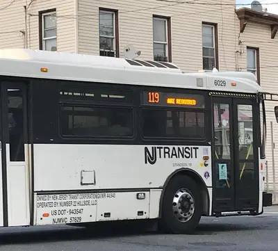 a white and black bus parked on a street at Fireflies In NYC, Cozy, Private & New in Union City