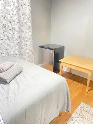 a bedroom with a bed and a wooden table at Rehan in Teaneck