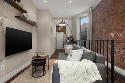 a living room with a couch and a brick wall at Sophisticated Stay in Vibrant Manhattan in New York