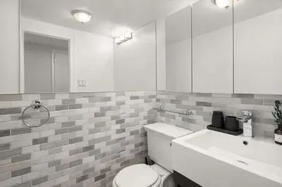 a bathroom with a white toilet and a sink at Sophisticated Stay in Vibrant Manhattan in New York