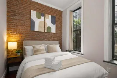 a bedroom with a bed and a brick wall at Sophisticated Stay in Vibrant Manhattan in New York