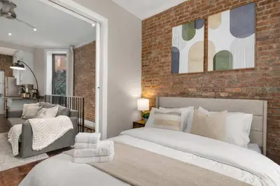 a bedroom with two beds and a brick wall at Sophisticated Stay in Vibrant Manhattan in New York