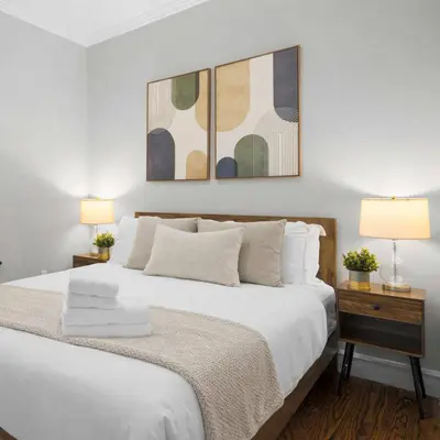 a bedroom with a large white bed with two lamps at Modern Manhattan Haven Near Everything in New York
