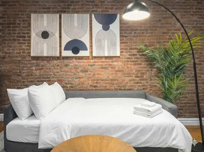 a bedroom with a bed and a brick wall at Modern Manhattan Haven Near Everything in New York