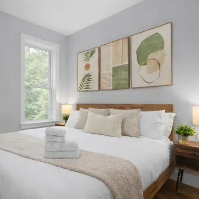 a bedroom with a large white bed with two windows at Modern Manhattan Haven Near Everything in New York