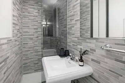 a white bathroom with a sink and a shower at Modern Manhattan Haven Near Everything in New York