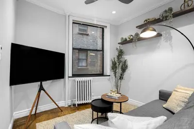 a living room with a couch and a flat screen tv at Modern Manhattan Stay in Prime Spot in New York