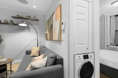 a living room with a couch and a washing machine at Modern Manhattan Stay in Prime Spot in New York