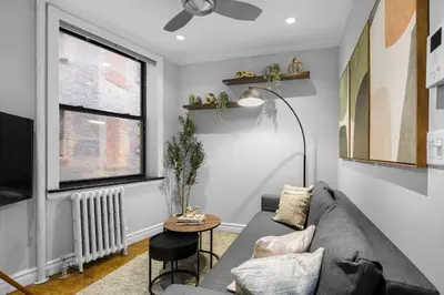 a living room with a gray couch and a window at Modern Manhattan Stay in Prime Spot in New York