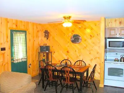 a dining room with a table and a kitchen at Secluded Cabin Nestled in the Mountains near the Tioga State Forest, Pennsylvania in Blossburg