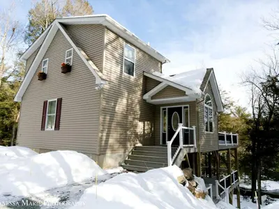 a house with snow in front of it at Rustic Getaway Surrounded by Enchanting Forest near Philadelphia, Pennsylvania in Jim Thorpe