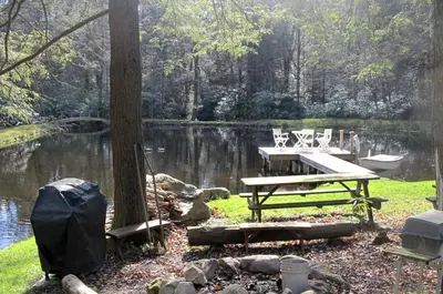 a picnic table and bench next to a lake at Rustic Getaway Surrounded by Enchanting Forest near Philadelphia, Pennsylvania in Jim Thorpe