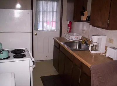 a small kitchen with a sink and a refrigerator at Quaint Lakefront Cabin Rental in Harveys Lake near Wilkes-Barre, Pennsylvania in Harveys Lake