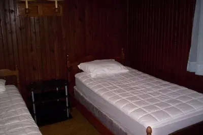 a bedroom with two twin beds in a room at Quaint Lakefront Cabin Rental in Harveys Lake near Wilkes-Barre, Pennsylvania in Harveys Lake