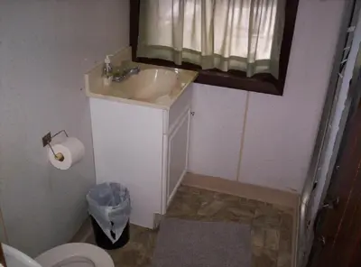 a bathroom with a sink and a toilet and a mirror at Quaint Lakefront Cabin Rental in Harveys Lake near Wilkes-Barre, Pennsylvania in Harveys Lake