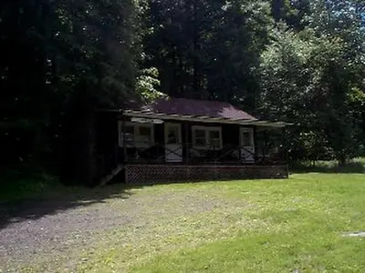 a small house in the middle of a field at Cozy Rustic Cabin Rental on Shore of Harveys Lake in Luzerne County, Pennsylvania in Harveys Lake