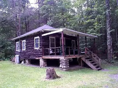a log cabin in the middle of a forest at Beautiful Log Cabin Rental in Harveys Lake near Back Mountain, Pennsylvania in Harveys Lake