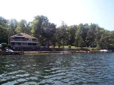 a large lake with a large building in the background at Beautiful Log Cabin Rental in Harveys Lake near Back Mountain, Pennsylvania in Harveys Lake