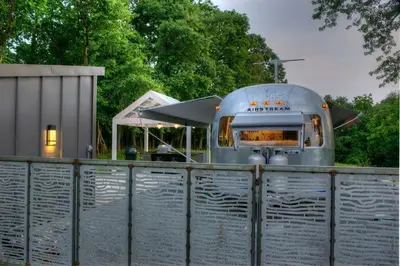 a school bus is parked behind a fence at Unique Accommodation for a Glamping Getaway in Columbia, Pennsylvania in Columbia