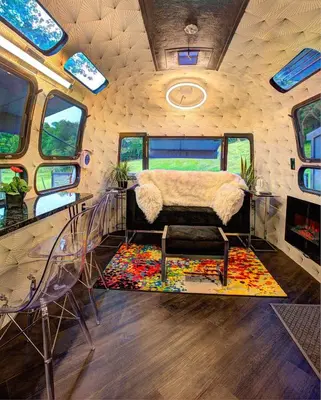 a room with a bed and chairs in a bus at Unique Accommodation for a Glamping Getaway in Columbia, Pennsylvania in Columbia
