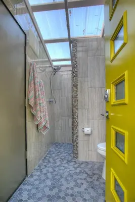 a bathroom with a shower and a yellow door at Unique Accommodation for a Glamping Getaway in Columbia, Pennsylvania in Columbia
