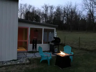 a backyard with two chairs and a table and a grill at Modern Cottage Rental on a Peaceful Farm near Amish Country in Pennsylvania in Columbia