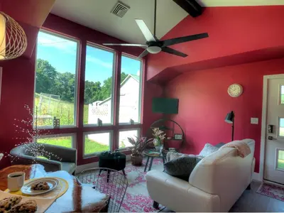 a living room with red walls and a ceiling fan at Modern Cottage Rental on a Peaceful Farm near Amish Country in Pennsylvania in Columbia